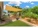 Serene backyard with a shade sail, lush tropical plants, and a brick patio at 11423 Brighton Knoll Loop, Riverview, FL 33579