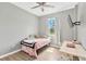 Cozy bedroom with light gray walls, wood-look flooring, and a window providing natural light at 11423 Brighton Knoll Loop, Riverview, FL 33579