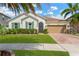 Charming single-story home with a well-manicured lawn, lush landscaping, and a brick driveway leading to a two-car garage at 11423 Brighton Knoll Loop, Riverview, FL 33579