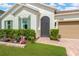 Close up of home's front entrance featuring green shutters, brick paver walkway, and colorful garden at 11423 Brighton Knoll Loop, Riverview, FL 33579