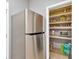 Kitchen pantry featuring built-in shelves, ample storage, and stainless steel refrigerator at 11423 Brighton Knoll Loop, Riverview, FL 33579