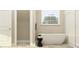 Bright bathroom featuring a soaking tub, separate shower, and modern finishes at 11546 Flourish Dr, Land O Lakes, FL 34637