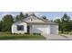 Charming home exterior featuring a two-car garage, blue shutters, and lush green lawn at 11546 Flourish Dr, Land O Lakes, FL 34637