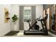 Home gym featuring a Peloton bike, a treadmill, and decorative shelves at 11546 Flourish Dr, Land O Lakes, FL 34637