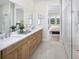 Beautiful bathroom featuring a double vanity, a glass-enclosed shower, and neutral tile at 11730 Myakka Blue Dr, Venice, FL 34293
