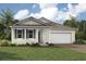 Charming single-story home with a well-manicured lawn, a two-car garage and tropical landscaping at 11730 Myakka Blue Dr, Venice, FL 34293