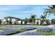 Modern community buildings featuring palm trees, blue flowers, and ample parking at 11730 Myakka Blue Dr, Venice, FL 34293