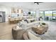Open-concept living room with stylish furniture, an island kitchen, and abundant natural light at 11730 Myakka Blue Dr, Venice, FL 34293