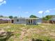 View of backyard featuring partial fencing, a small patio, and a well-maintained lawn at 1213 W Camellia Dr, Brandon, FL 33510