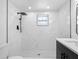 Modern bathroom featuring white marble-look tile, rain shower head and sleek vanity at 1213 W Camellia Dr, Brandon, FL 33510