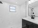 Modern bathroom featuring marble-look tile, a sleek vanity, contemporary fixtures, and a glass-enclosed shower at 1213 W Camellia Dr, Brandon, FL 33510