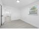 Bright bedroom with light wood-look floors, neutral walls, and a peek into the bathroom at 1213 W Camellia Dr, Brandon, FL 33510