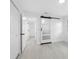Bright bedroom with modern barn door and light wood-look floors, offering a stylish and serene space at 1213 W Camellia Dr, Brandon, FL 33510
