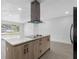 Modern kitchen featuring stainless steel appliances, an island with a cooktop, a range hood and a quartz countertop at 1213 W Camellia Dr, Brandon, FL 33510