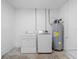 Functional laundry room features a modern washer and dryer, along with a water heater at 1213 W Camellia Dr, Brandon, FL 33510