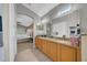 Open bathroom with a granite countertop, dual sinks, a tub, and bedroom access at 12510 Loquat Way, Tampa, FL 33626