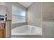 Bright bathroom with a white soaking tub, tiled wall, and neutral color palette at 12510 Loquat Way, Tampa, FL 33626