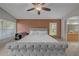 Comfortable main bedroom with a tufted headboard, ceiling fan, and ensuite bath access at 12510 Loquat Way, Tampa, FL 33626