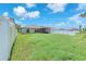 Expansive, grassy backyard with white fencing and mature trees in the distance at 12907 Wildflower Meadow Dr, Riverview, FL 33579