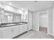 Bathroom with double vanity, granite countertops, framed mirror, a walk-in shower and linen storage at 12907 Wildflower Meadow Dr, Riverview, FL 33579