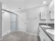 Bright bathroom features double vanity with granite counters and a glass-enclosed shower at 12907 Wildflower Meadow Dr, Riverview, FL 33579