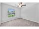 Bedroom featuring neutral carpet, a ceiling fan, and a view of the landscaped yard at 12907 Wildflower Meadow Dr, Riverview, FL 33579