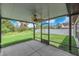 Screened lanai boasts a ceiling fan with a view of the grassy, fenced backyard at 12907 Wildflower Meadow Dr, Riverview, FL 33579
