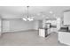 Open living space with tile floors flows between a kitchen with a large island and a dining area at 12907 Wildflower Meadow Dr, Riverview, FL 33579