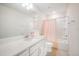 Well-lit bathroom with a single sink vanity, a large mirror, and a bathtub with a shower featuring a pink curtain at 13157 Peachleaf Ave, Riverview, FL 33579