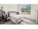 Bedroom with a large window providing ample natural light and a comfortable gray cushioned headboard at 13157 Peachleaf Ave, Riverview, FL 33579