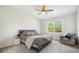 Comfortable bedroom with neutral décor, ceiling fan, and a window with lush green views at 13157 Peachleaf Ave, Riverview, FL 33579