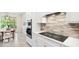 Close up of sleek, modern kitchen with mosaic backsplash, stainless steel oven and cooktop at 13157 Peachleaf Ave, Riverview, FL 33579