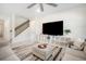 Cozy living room with staircase, modern furniture, large TV and stylish rug at 13157 Peachleaf Ave, Riverview, FL 33579