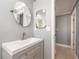 Modern bathroom with gray vanity, faucet and round mirror at 14045 90Th Pl, Seminole, FL 33776