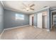 Bedroom with double closets, neutral walls, tile flooring, and a ceiling fan at 14045 90Th Pl, Seminole, FL 33776