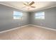 Light-filled bedroom with tile floor, two windows, and ceiling fan at 14045 90Th Pl, Seminole, FL 33776