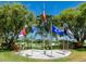 Community center with multiple flags and nice landscaping and trees at 14045 90Th Pl, Seminole, FL 33776