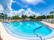 Community pool on a sunny day with trees and clear skies at 14045 90Th Pl, Seminole, FL 33776