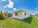 Rear exterior view showing screened in porch, siding, and green lawn at 14045 90Th Pl, Seminole, FL 33776