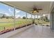 Screened-in lanai with tiled floor, ceiling fan, and views of the green backyard at 14045 90Th Pl, Seminole, FL 33776