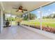 Screened-in lanai with tiled floor, ceiling fan, and views of the manicured lawn at 14045 90Th Pl, Seminole, FL 33776