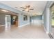 Expansive living space with ceiling fans, tiled floor, and seamless flow to kitchen at 14045 90Th Pl, Seminole, FL 33776