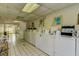 Well-lit community laundry room with multiple washers and tiled floors for easy maintenance at 1406 Arrowhead W Cir, Clearwater, FL 33759