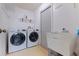 Functional laundry room with sink, shelving and modern, front-load washer and dryer appliances at 201 Westwood N Ter, St Petersburg, FL 33710