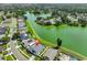 An aerial view of a home with a pool, located on the shores of a green lake and surrounded by lush trees at 2021 Elk Spring Dr, Brandon, FL 33511