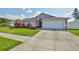Front view of the single Gathering home with a two-car garage and lush lawn at 2021 Elk Spring Dr, Brandon, FL 33511