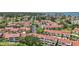 Expansive aerial view of a residential community showcasing multiple buildings, lush landscaping and a glimpse of the waterway at 2363 Hanover Dr, Dunedin, FL 34698