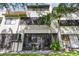 Backyard featuring palm trees, green grass, and outdoor patio seating with screen doors at 2363 Hanover Dr, Dunedin, FL 34698
