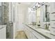 Bathroom featuring double sinks with white cabinetry, a shower with mosaic tile, and modern fixtures at 2363 Hanover Dr, Dunedin, FL 34698