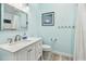 Bright bathroom with a modern vanity, framed mirror, and a shower with a white curtain at 2363 Hanover Dr, Dunedin, FL 34698